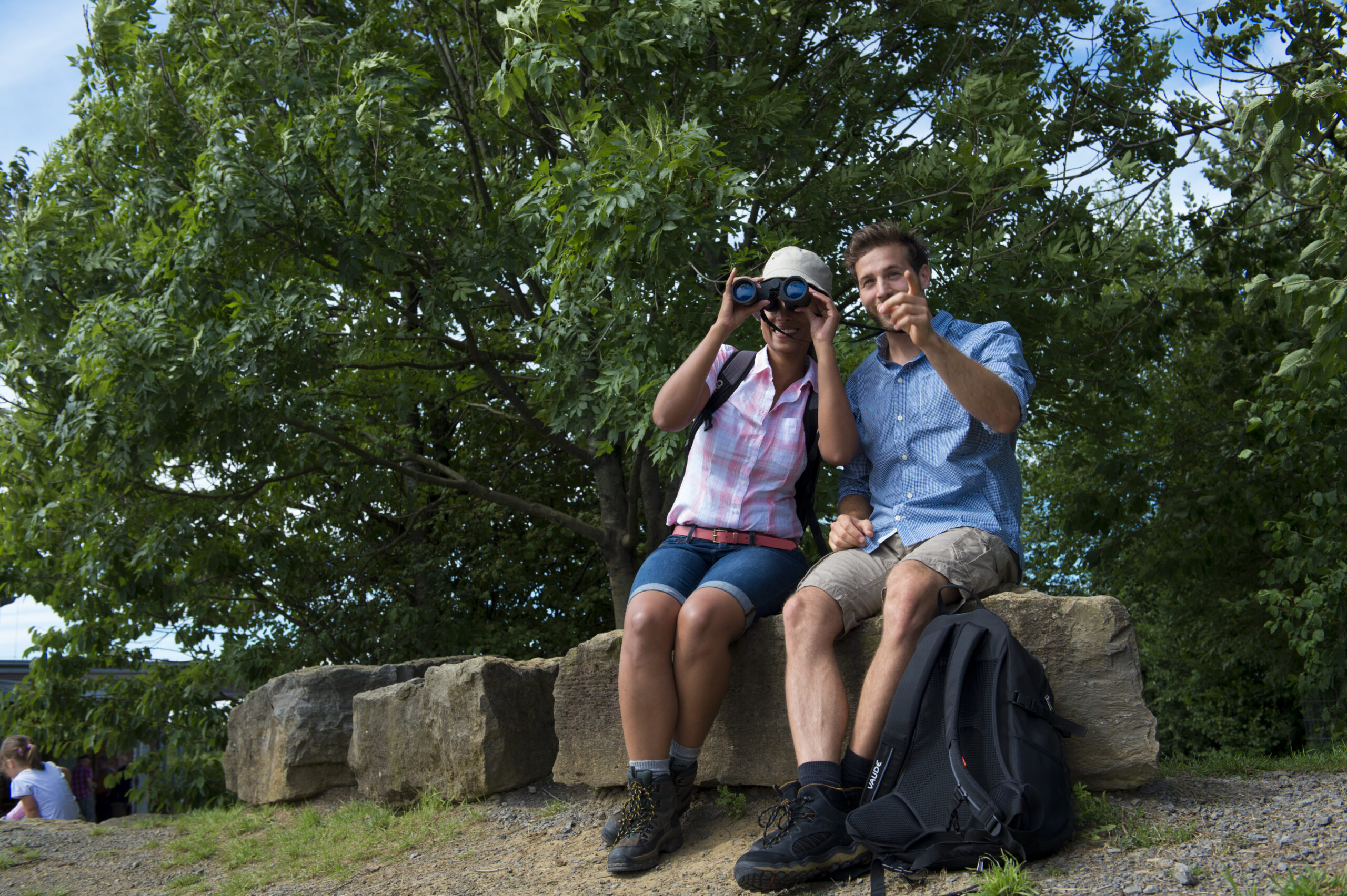 Wanderungen im Weserbergland: Zwei Wandernde mit Fernglas am Aussichtspunkt Hohenstein.